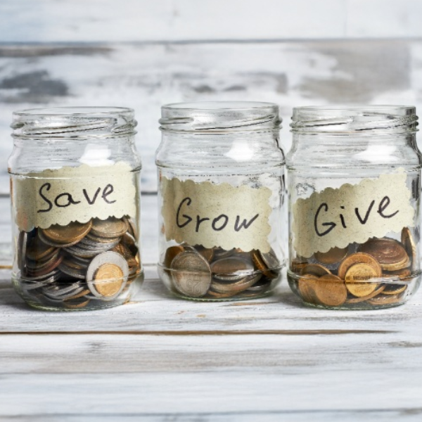 A clean, simple visual of three labeled jars or envelopes on a neutral table.. Save, Spend, Give.. with soft natural light, modern family aesthetic.